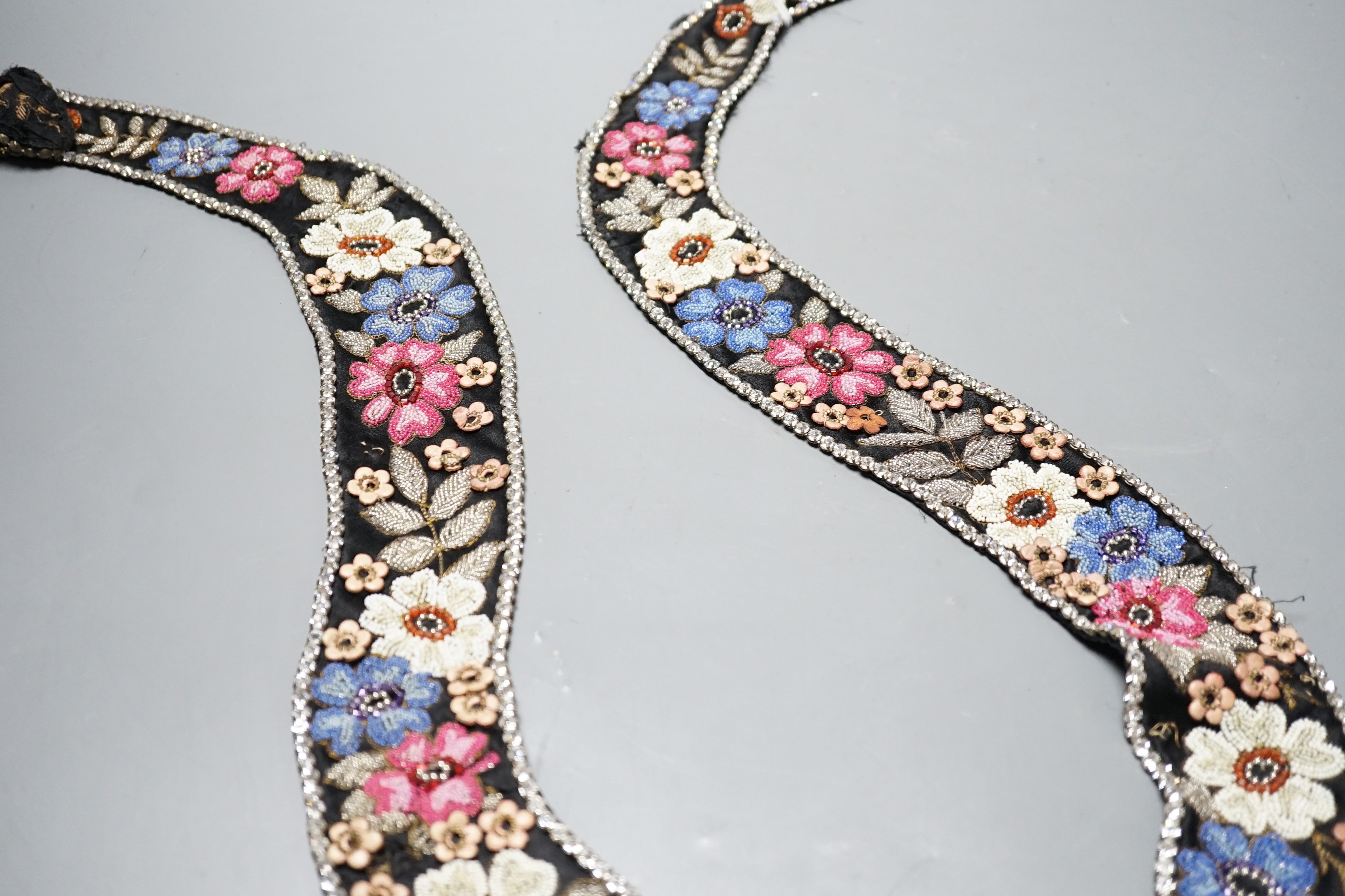 A 1920’s-30’s French beaded collar, the beads embroidered as flowers and leaves with leather applice flowers and diamanté edging, 115 cms long